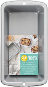 Retail-packaged Wilton Recipe Right medium loaf pan with label and baked goods on packaging.