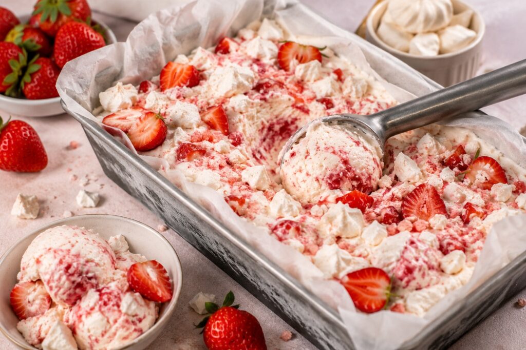 Kom met romig roze aardbeien Eton Mess ijs met meringuekruimels en verse aardbeien